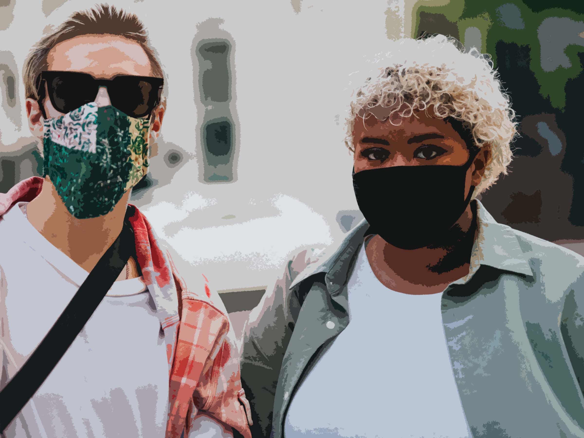 Two young people stand together wearing COVID-19 face masks. On the left is a White man and on the right is a Black woman
