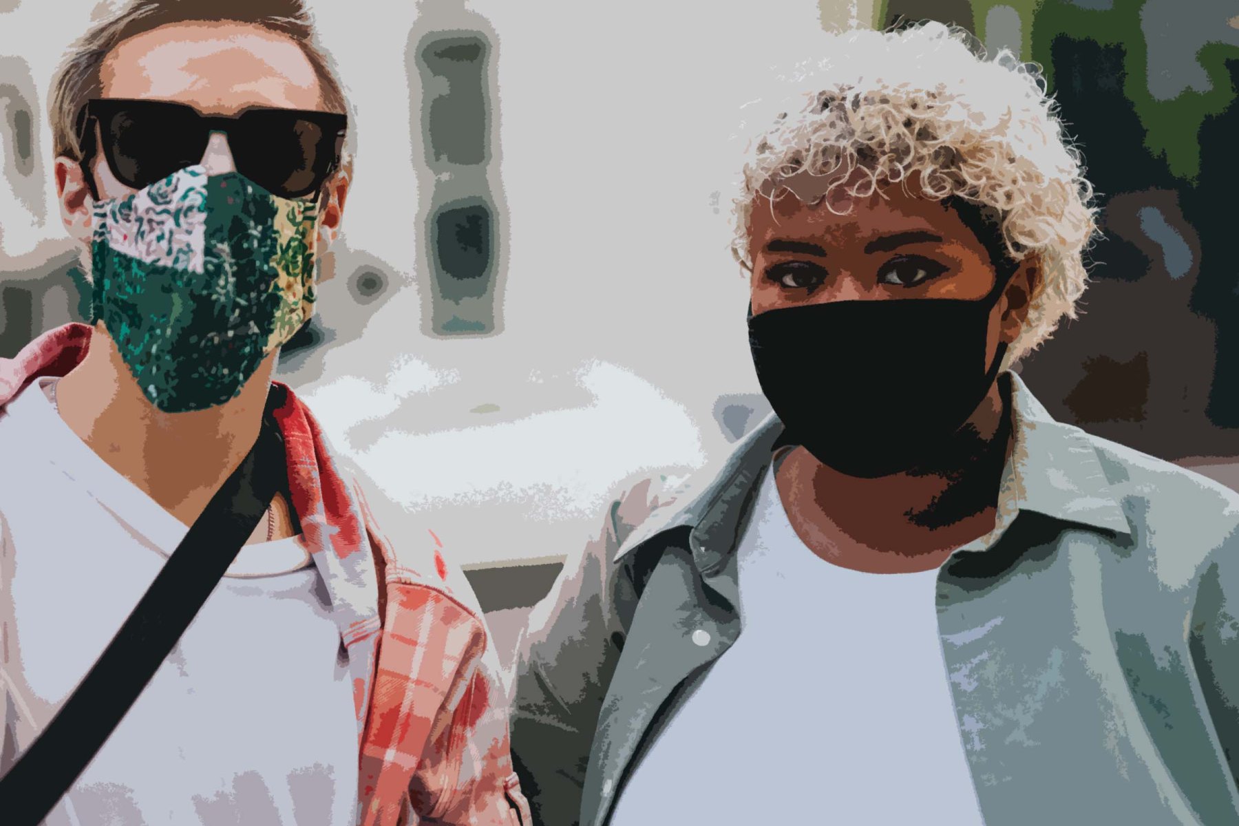 Two young people stand together wearing COVID-19 face masks. On the left is a White man and on the right is a Black woman